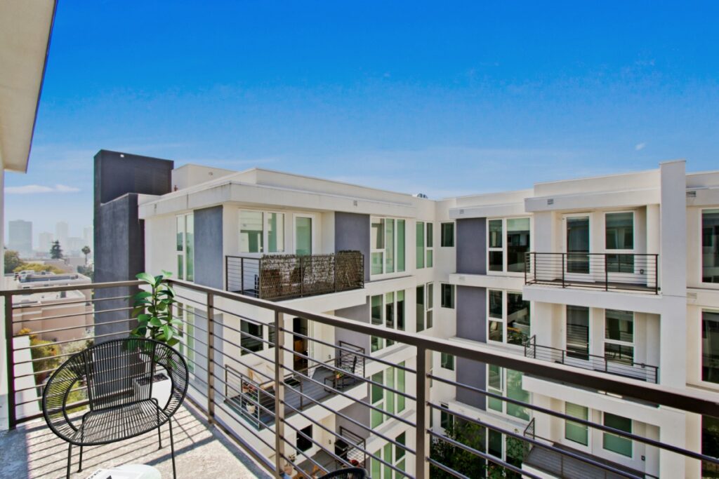Private balcony view overlooking modern apartment complex at SageLA Apartments